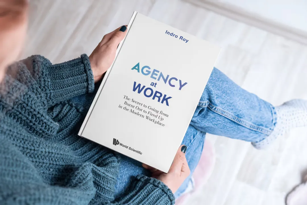 A reader with a copy of Agency at Work